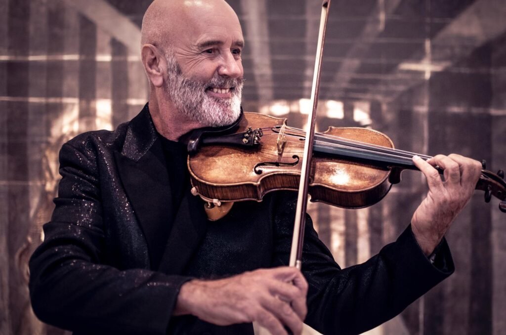 Edison Mouriño tocando el violín en un salón elegante